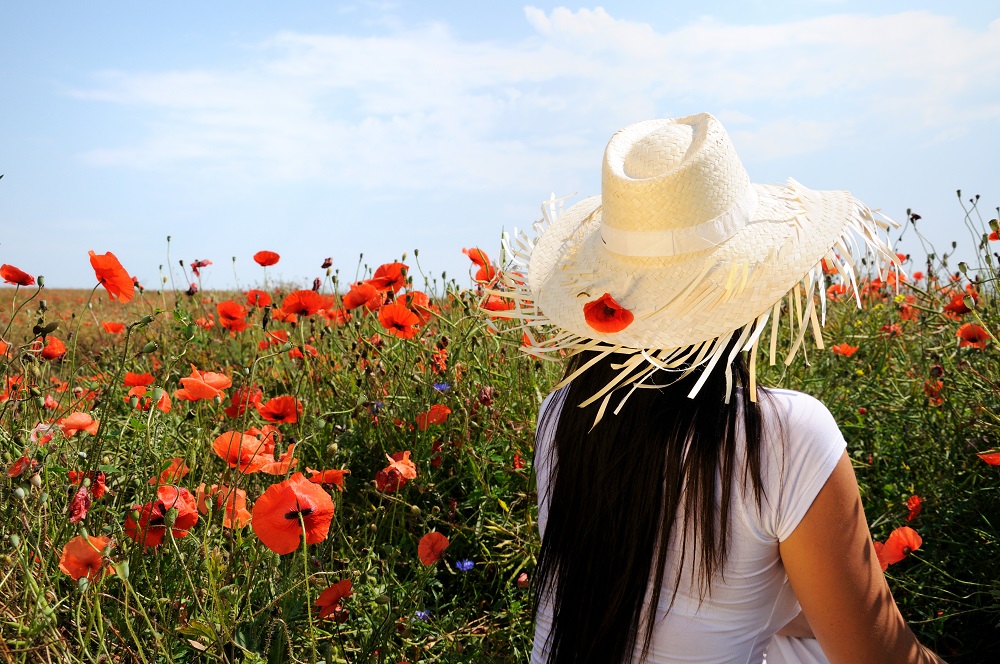 Young beautiful woman in poppy flowers