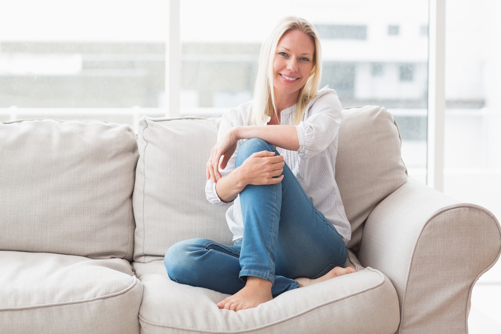 Portrait of happy woman sitting on sofa