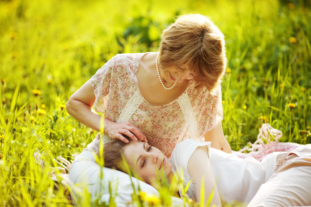 Happy Mother stroking sleeping daughter