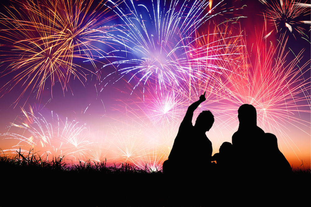 happy family sitting on floor and watching the fireworks