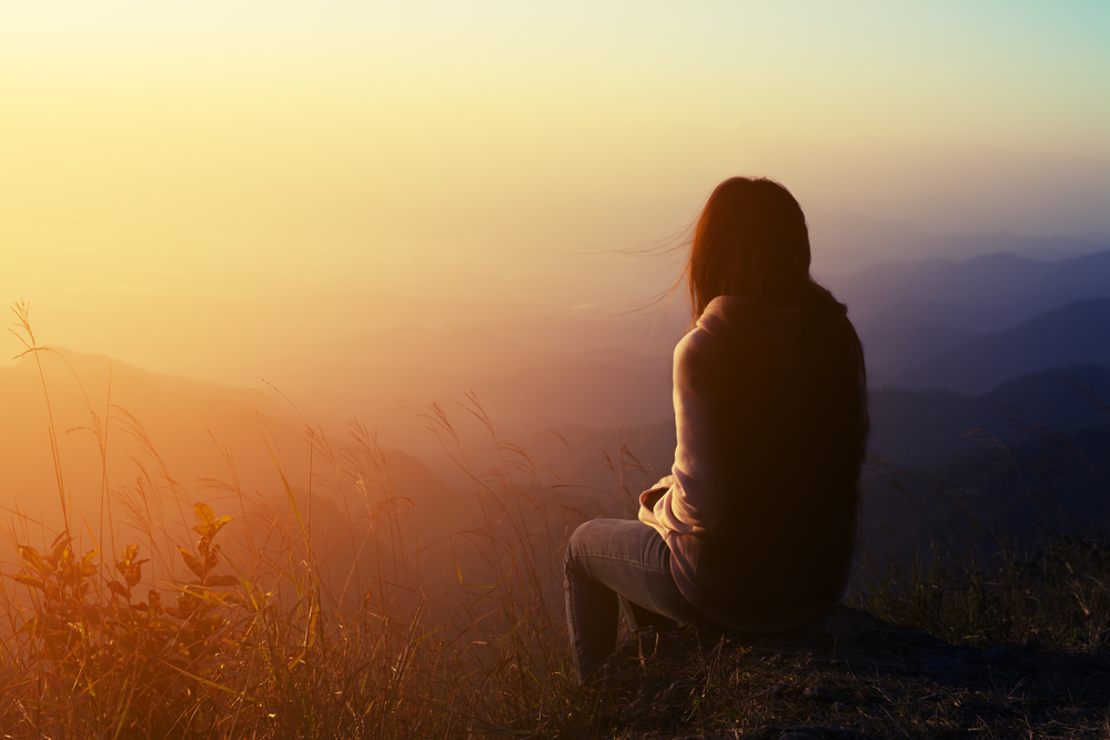 Silhouette,Woman,Sitting,On,Mountain,In,Morning,And,Vintage,Filter