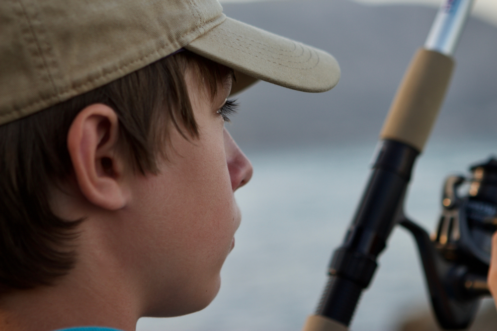 Caucasian,Teenage,Boy,Wearing,A,Baseball,Cap,,Fishing,,Close,Up