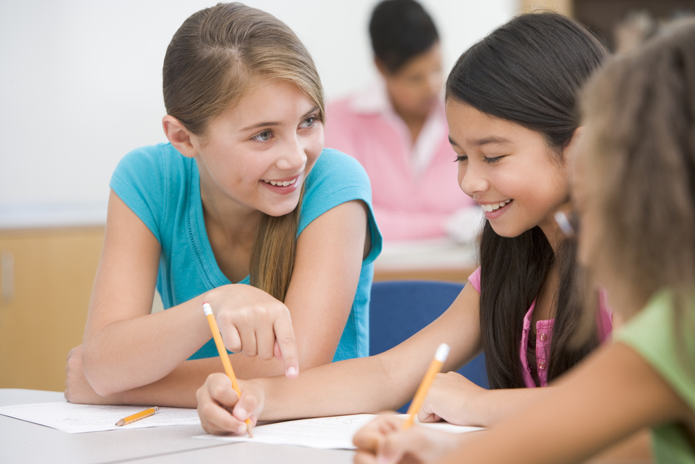 Three,Elementary,School,Pupils,Talking,In,Classroom