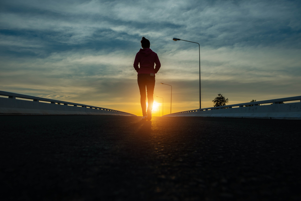 Silhouette,Woman,Walking,On,The,Street,At,Sunset.